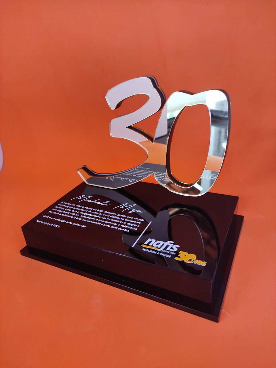 Troféu de acrílico com números espelhados e texto gravado em base preta.