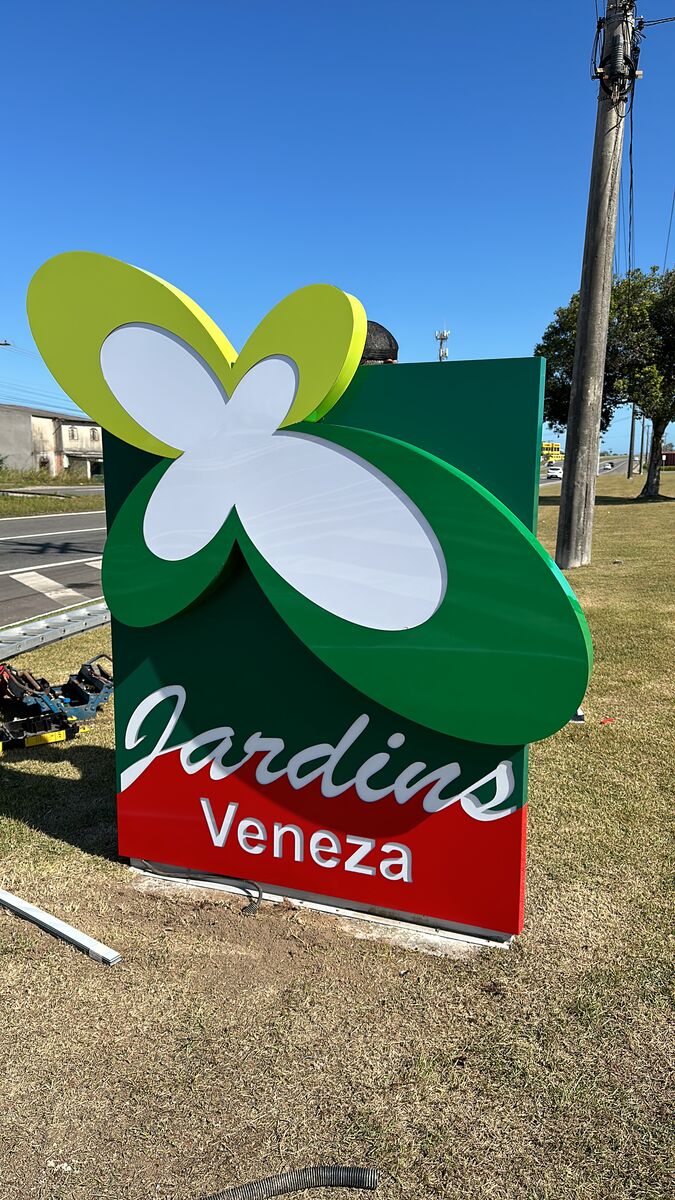 Grande letreiro com logo de borboleta e nome de empresa em letras 3D.