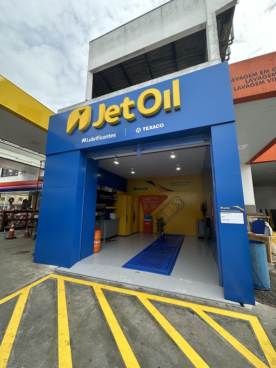 Fachada de centro automotivo revestida com painéis de ACM azul e letreiro em destaque.