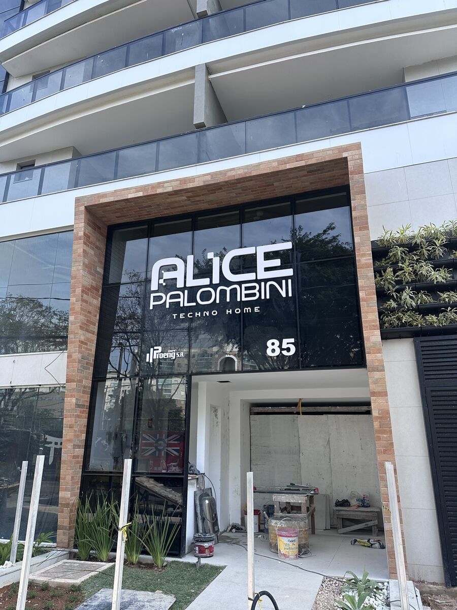 Letras e logomarca em adesivo aplicado em vidro de fachada comercial.