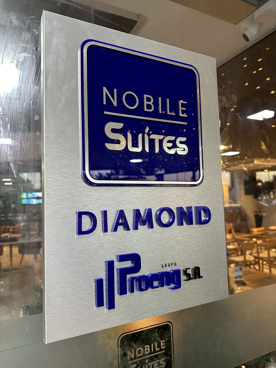 Placa de sinalização interna em aço escovado com logomarca e identidade do Nobile Suites.